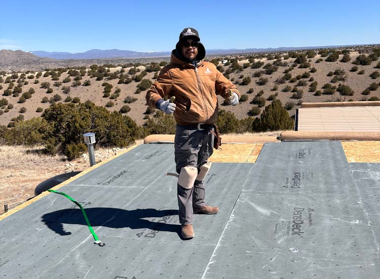 roofer smiling during flat roof replacement